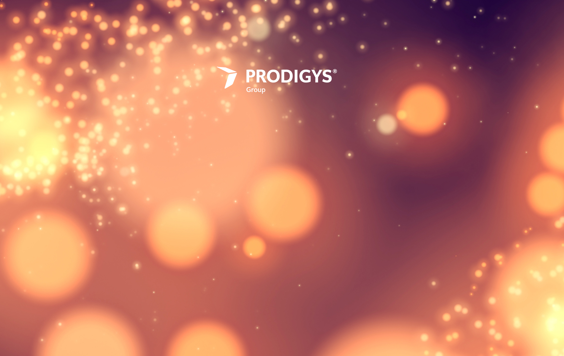 Grafica astratta con grandi sfere luminose arancioni e gialle sfocate su sfondo viola, accompagnate da piccoli punti scintillanti. In alto al centro è visibile il logo ‘Prodigys Group’.