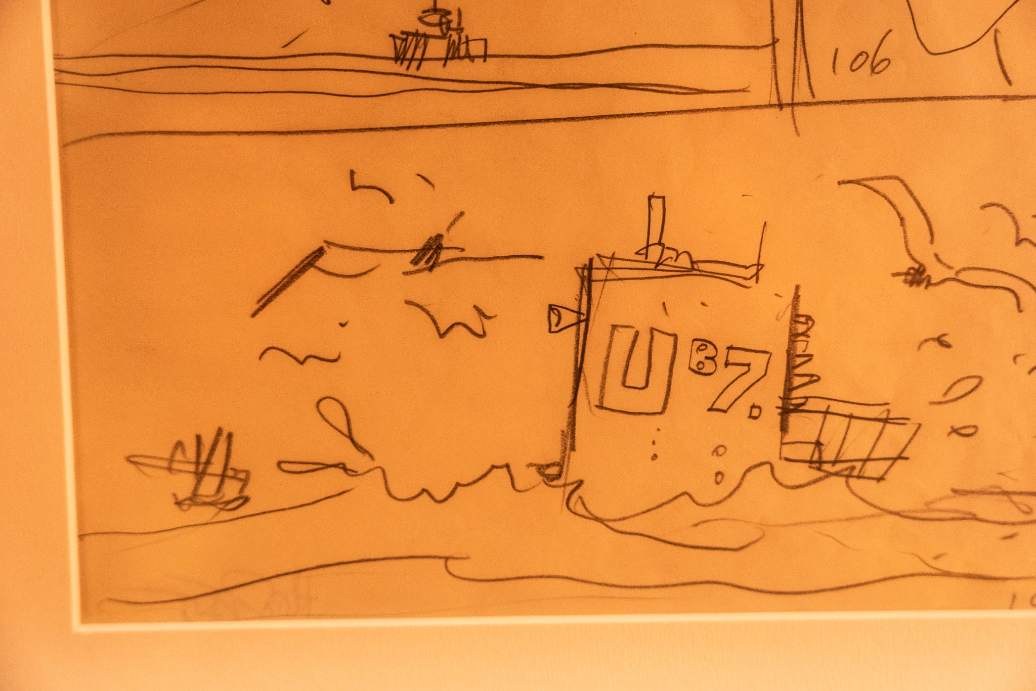 Schizzo a matita su foglio ingiallito che rappresenta un sommergibile con la sigla 'U 87' emergere tra le onde. Intorno al mezzo sono tratteggiate linee che suggeriscono spruzzi d’acqua e il movimento del mare. In alto si intravedono altri disegni di imbarcazioni e forme stilizzate, appartenenti a vignette adiacenti.
