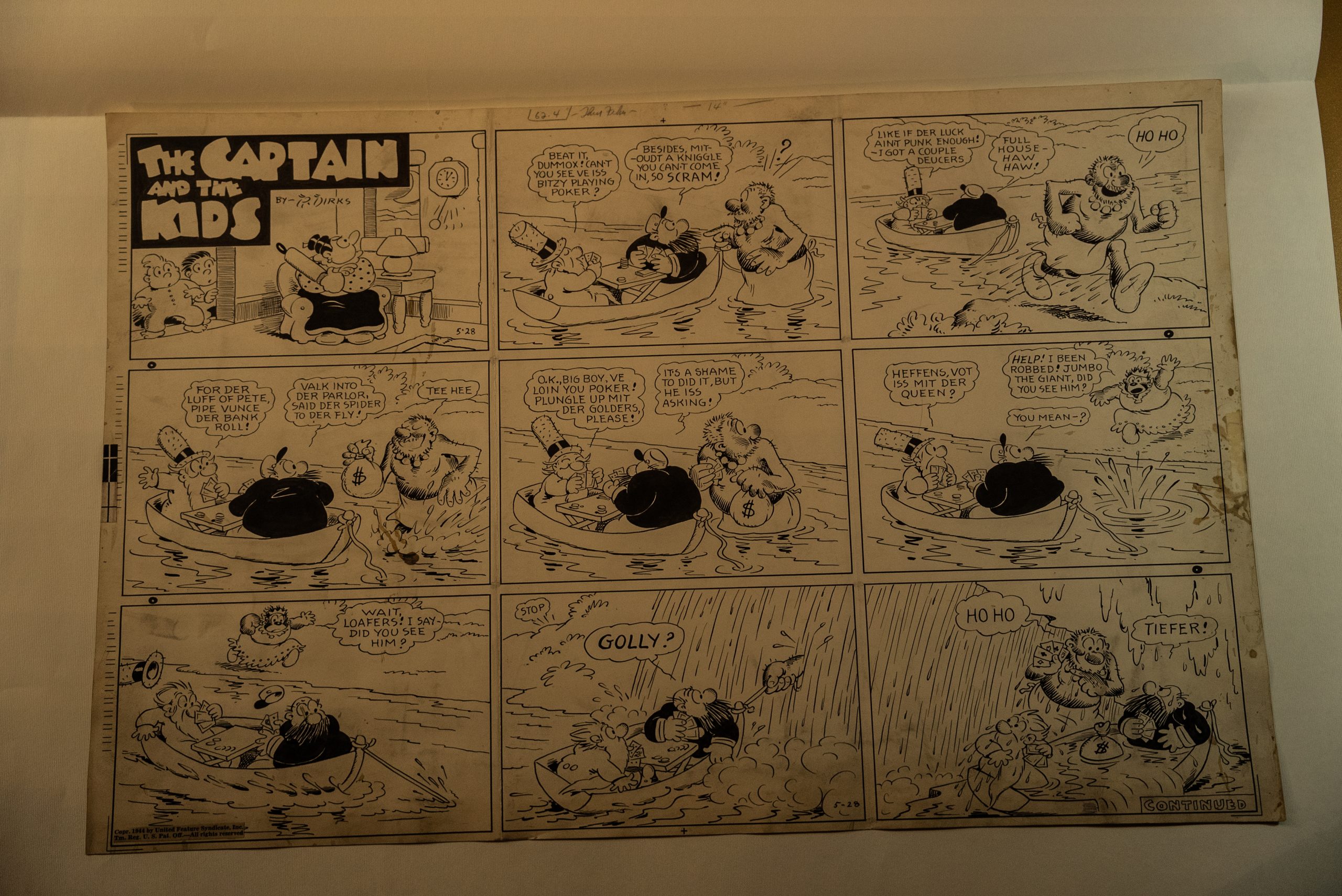 Una tavola originale in bianco e nero del fumetto "The Captain and the Kids" di Rudolph Dirks. La pagina è composta da nove vignette disposte in una griglia 3x3. La storia mostra i personaggi classici (ispirati a Bibì e Bibò) coinvolti in una gag comica su una barca a remi: due uomini giocano a poker mentre un terzo personaggio gigante si avvicina in acqua. Il foglio appare ingiallito dal tempo, con segni di usura e annotazioni a matita sui margini superiori, tipiche del materiale di produzione editoriale d'epoca.